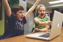 Children playing and pointing at computer